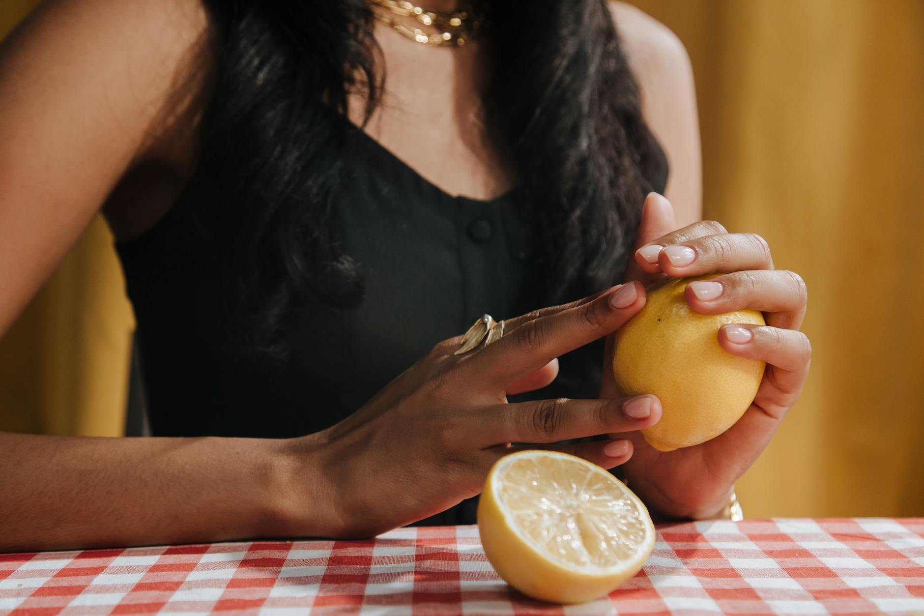 Hand holding a modern clitoral vibrator against a minimalist background, representing pleasure and sensuality.
