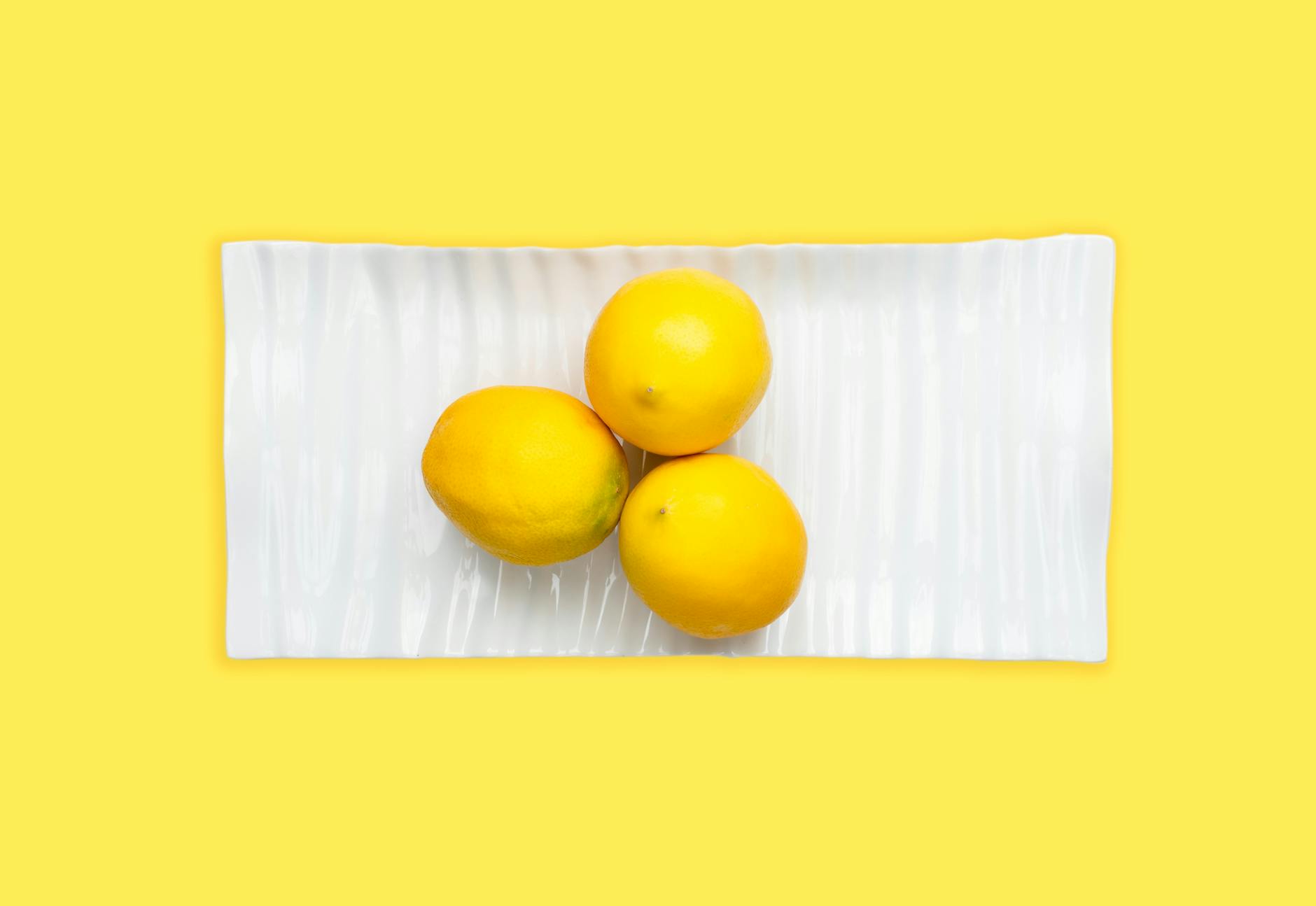 Bright yellow ripe lemons on a pastel background, representing fresh approaches to pleasure