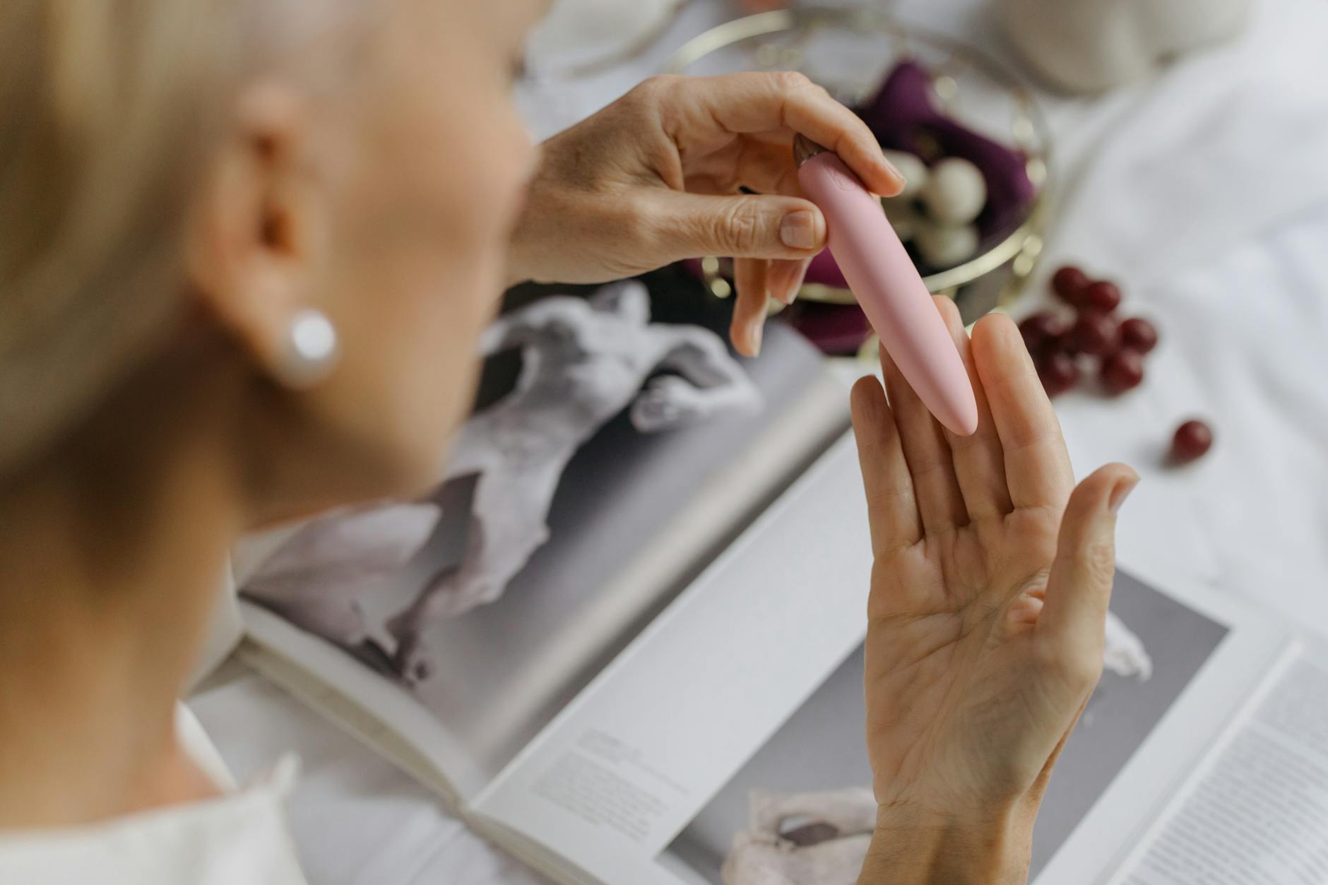 Person holding blue and pink silicone vibrators in thoughtful manner, representing couples exploring pleasure together