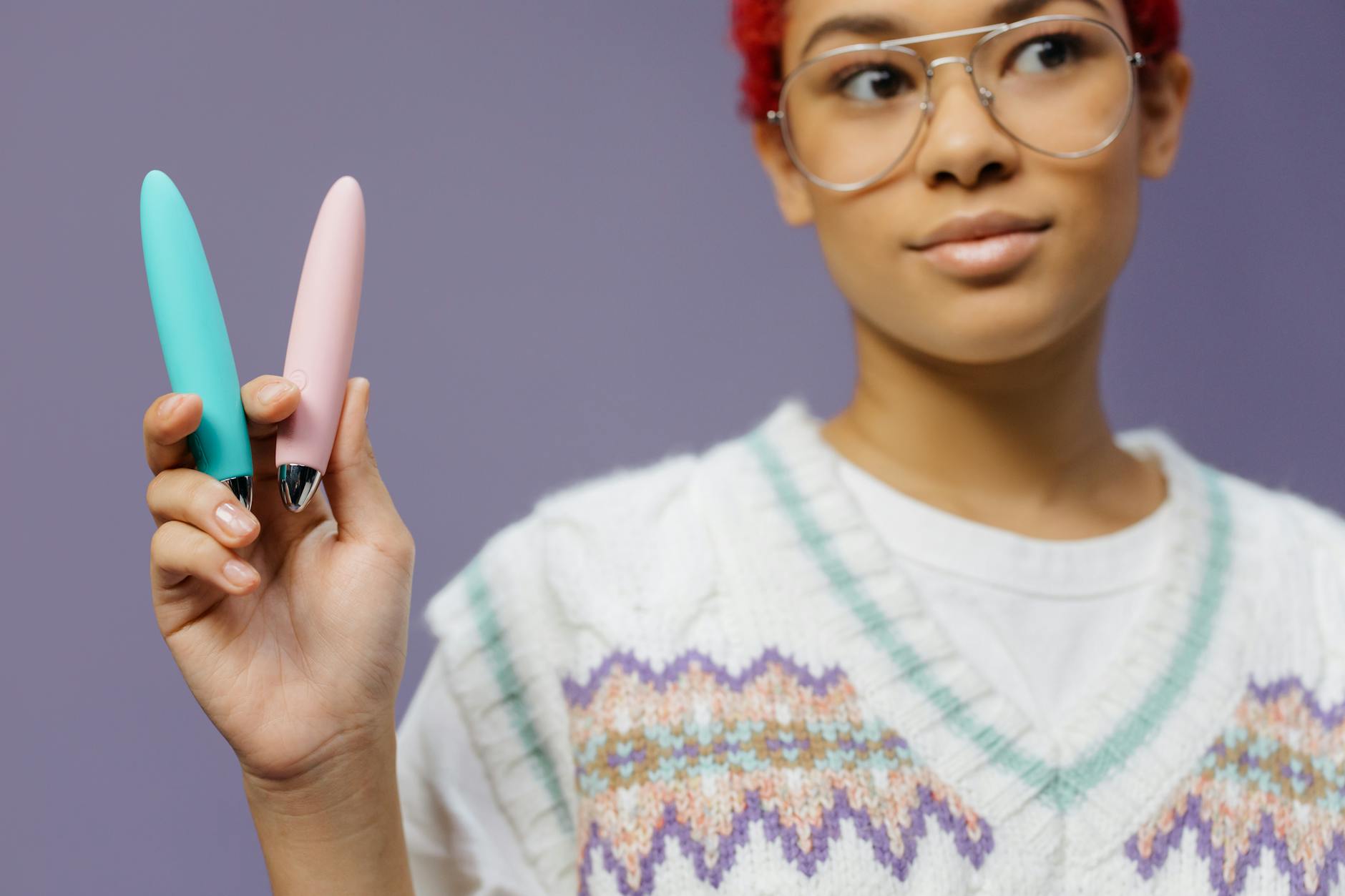 A person holds clitoral vibrators showing color and design options for pleasure exploration