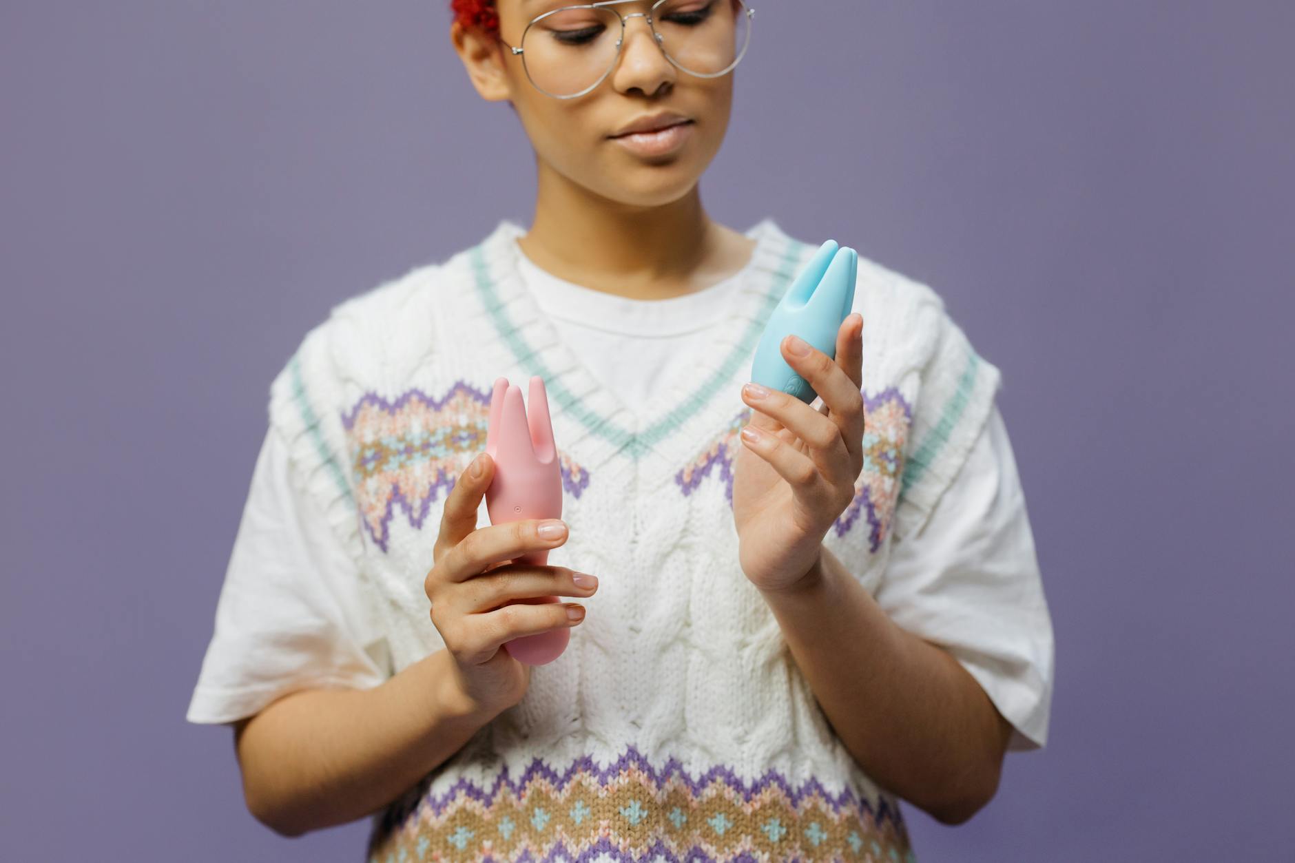 Woman holding lemon clitoral vibrator in contemplative manner