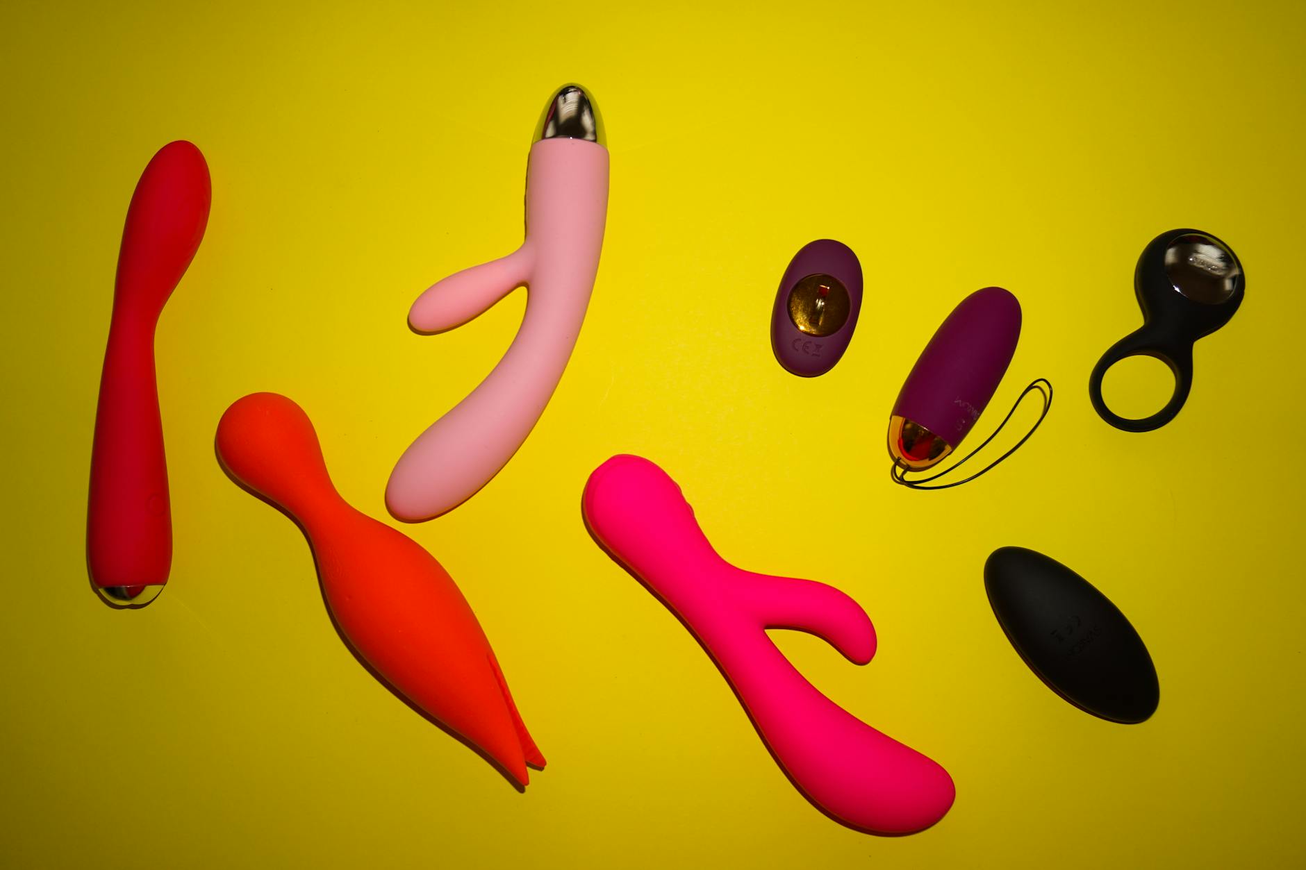 Array of vibrant clitoral vibrators displayed on bright background, showcasing various designs and styles
